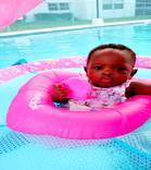 "Happy baby in pool with tube - A joyful baby floating in a pool with a tube, enjoying water play and summer fun."